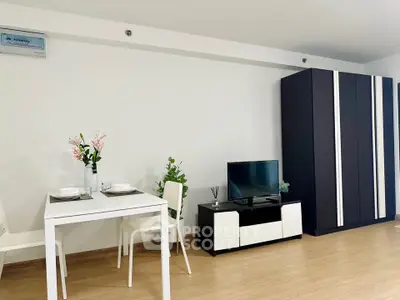 Modern living room with sleek furniture and minimalist decor, featuring a TV stand and dining area.