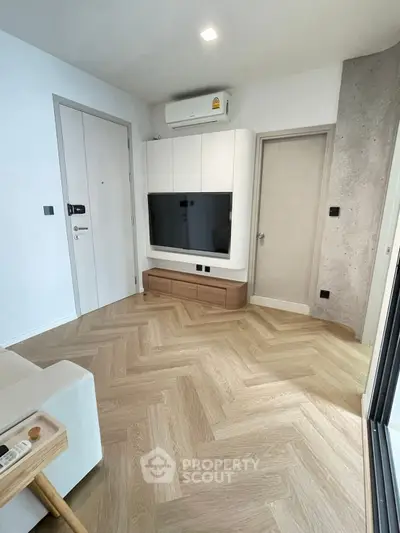 Modern living room with herringbone flooring and wall-mounted TV