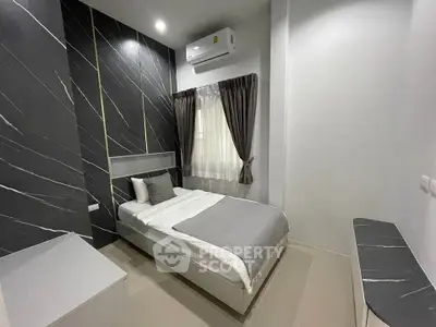Modern bedroom with sleek design and air conditioning, featuring elegant dark accent wall and cozy bedding.