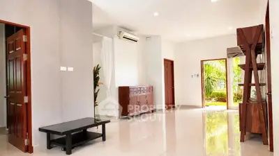 Spacious living room with modern decor and garden view, perfect for relaxation and entertaining.