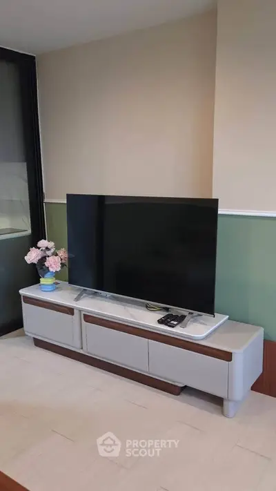 Modern living room with sleek TV stand and flat-screen TV, perfect for entertainment.
