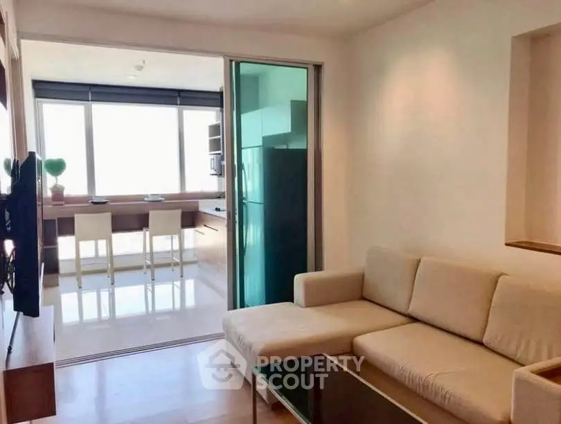 Modern living room with open kitchen and large windows for natural light
