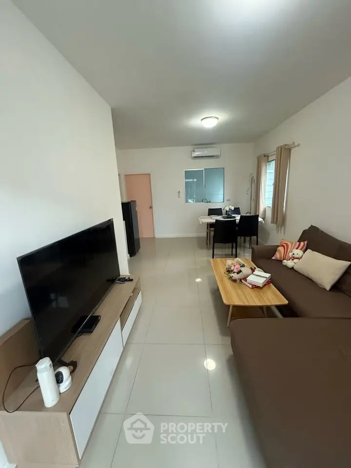 Modern living room with sleek furniture and large TV, perfect for relaxation and entertainment.