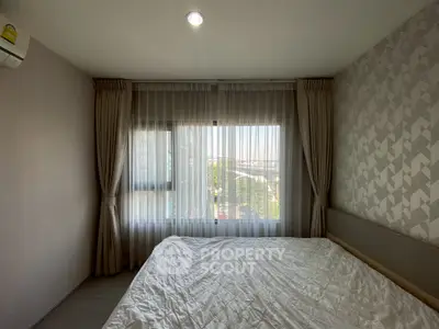 Cozy bedroom with large window and stylish curtains offering a serene view, perfect for relaxation.