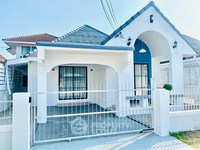 Charming white single-story house with modern design and spacious driveway.
