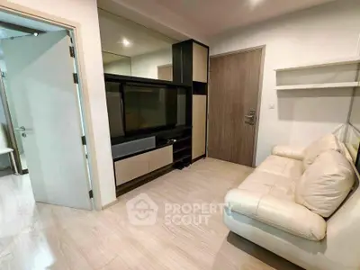 Modern living room with sleek furniture and wooden flooring, featuring a cozy white sofa and built-in entertainment unit.