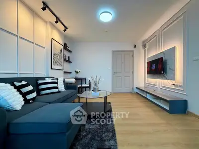 Modern living room with stylish decor and wall-mounted TV, featuring a cozy sofa and elegant lighting.