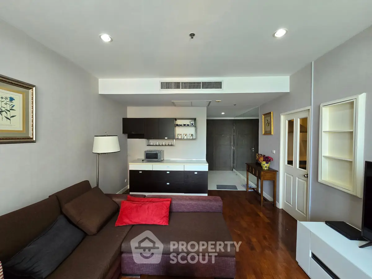 Modern living room with stylish furniture and open kitchen layout in a cozy apartment.