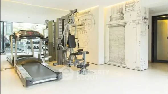 Modern gym with state-of-the-art equipment and stylish decor in luxury residential building.