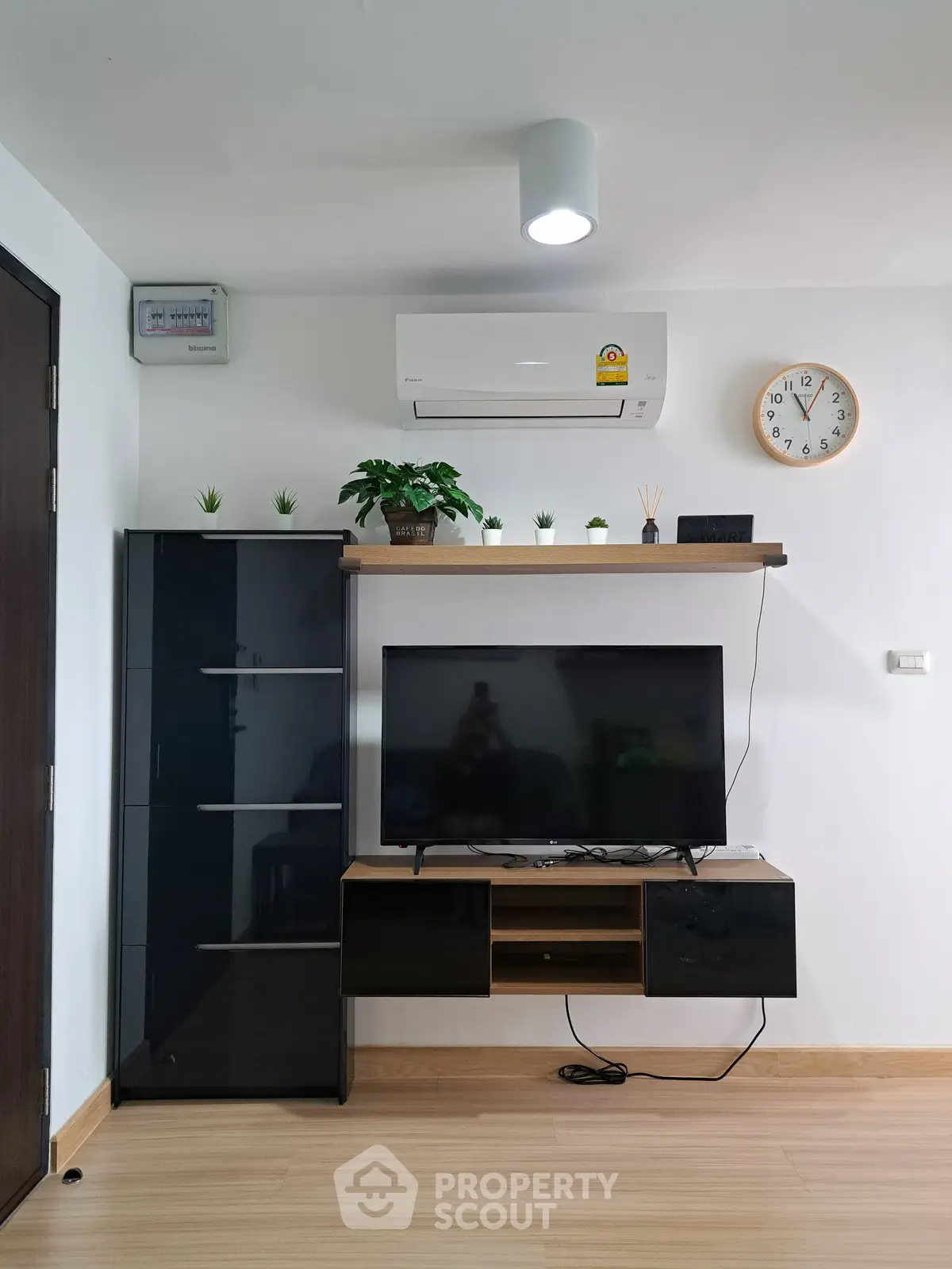 Modern living room with sleek TV stand, air conditioning, and minimalist decor.