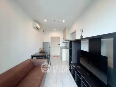 Modern living room with open kitchen layout and sleek furniture in a cozy apartment.