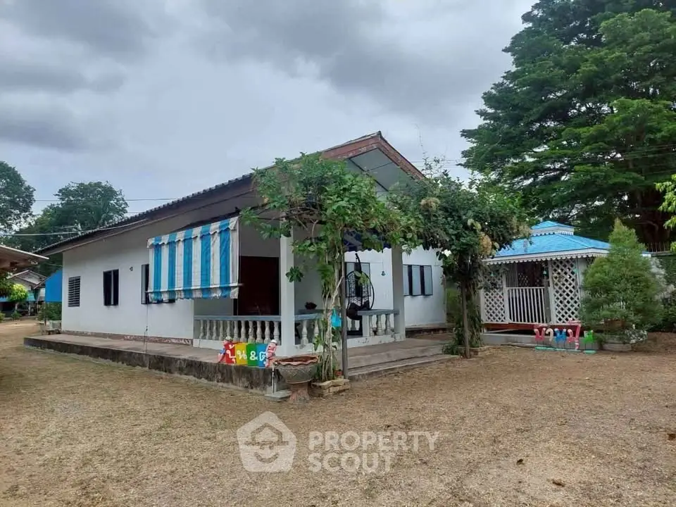 Charming single-story home with a spacious yard and lush greenery, perfect for family living.