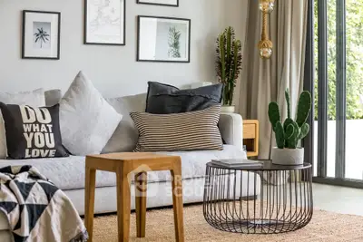 Stylish living room with modern decor, cozy sofa, and natural light from large windows.