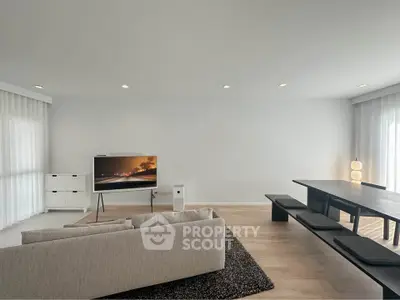 Spacious modern living room with sleek furniture and large windows for natural light.