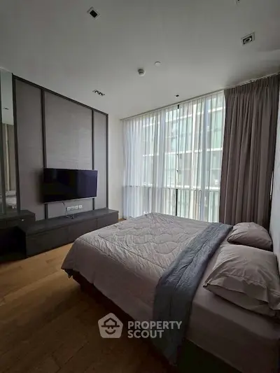 Modern bedroom with large window and stylish decor in a luxury apartment.
