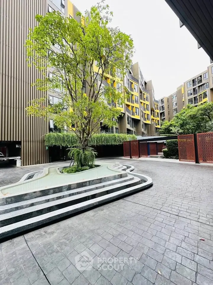 Modern apartment building with landscaped courtyard and unique architectural design.