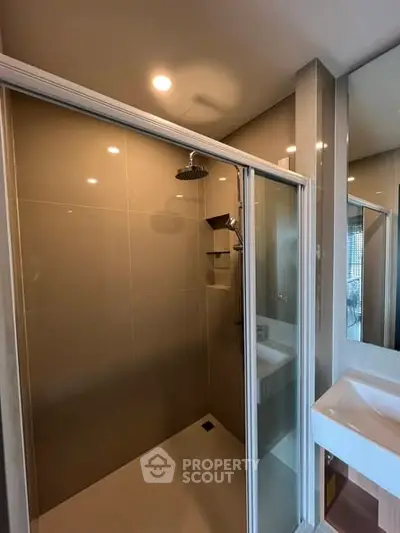 Modern bathroom with glass shower enclosure and sleek sink design