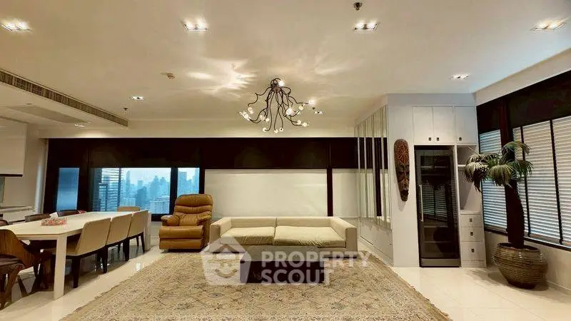 Spacious living room with modern decor and city view, featuring elegant chandelier and comfortable seating.