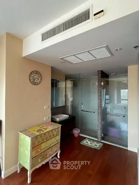 Modern bathroom with glass shower and stylish vanity in elegant apartment.