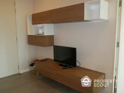 Modern minimalist living room with sleek wooden entertainment unit and ample shelving, perfect for cozy family gatherings.