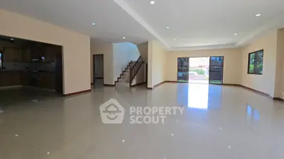 Spacious open-plan living room with modern kitchen and garden view.