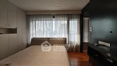 Modern bedroom with large window and sleek furnishings in urban apartment