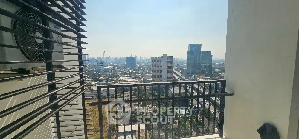 Stunning cityscape view from a high-rise balcony with modern railing and air conditioning unit.