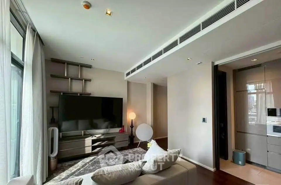 Modern living room with sleek design and large TV, perfect for relaxation.