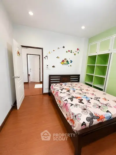 Charming bedroom with colorful butterfly-themed decor and built-in storage, perfect for a cozy living space.