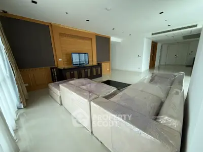 Spacious living room with modern decor and large sectional sofa in luxury apartment.