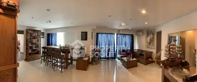 Spacious living room with elegant wooden furniture and large windows.
