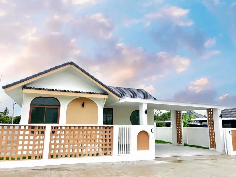 Charming single-story house with modern design and spacious carport under a picturesque sky.