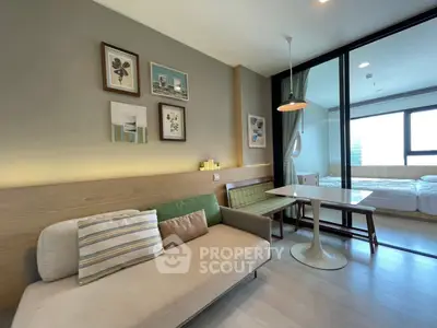 Modern living room with stylish decor and glass partition to bedroom
