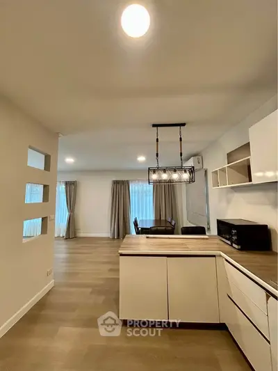 Spacious modern living room with open kitchen and elegant lighting
