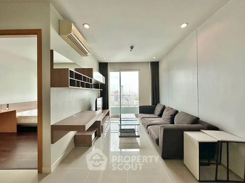 Modern living room with sleek furniture and city view from large window, perfect for urban living.