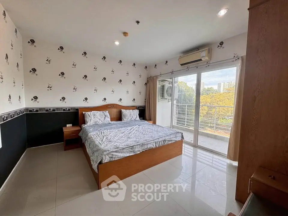 Spacious bedroom with balcony access and scenic view in modern apartment