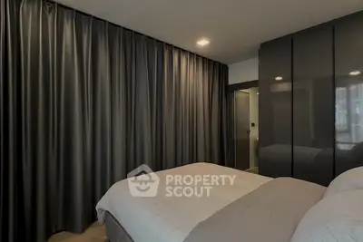 Modern bedroom with sleek design and dark curtains, featuring a cozy bed and stylish wardrobe.