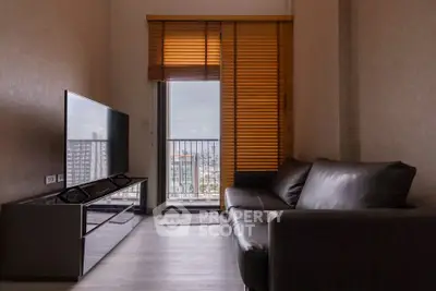 Modern living room with sleek furniture and city view from balcony.