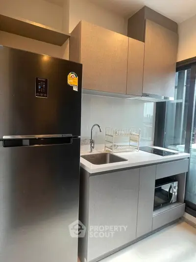 Modern kitchen with sleek appliances and ample storage in a stylish apartment.