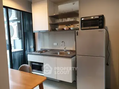 Modern kitchen with sleek appliances and open shelving in a stylish apartment.