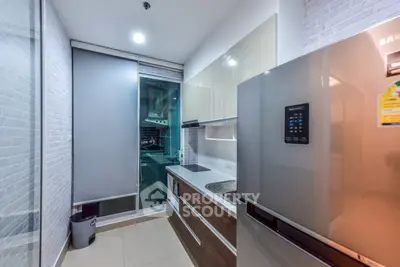 Modern kitchen with sleek cabinetry and stainless steel appliances in a contemporary apartment.
