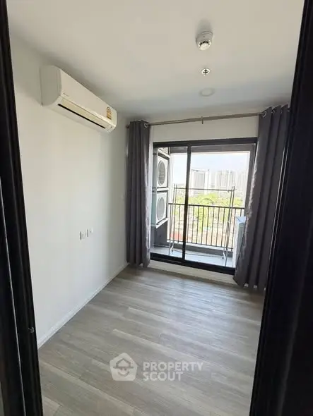 Bright room with air conditioning and balcony access, perfect for a cozy living space.