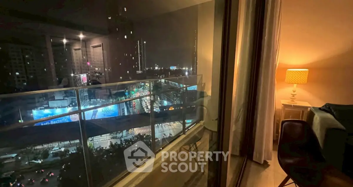 Stunning night city view from modern apartment balcony with cozy interior lighting.