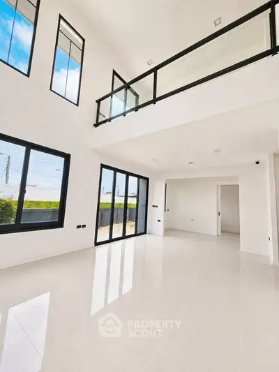 Spacious modern living room with high ceilings and large windows for natural light.