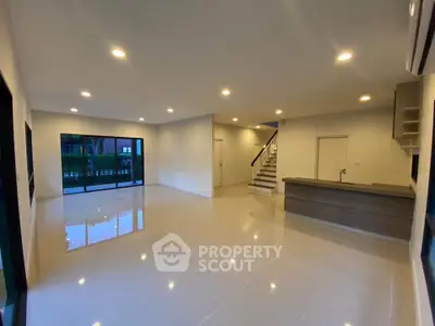 Spacious modern living room with sleek tile flooring and large windows.