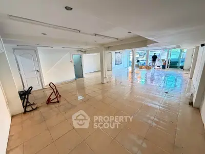 Spacious commercial space with tiled flooring and large windows for lease