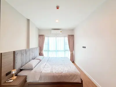Modern bedroom with natural light and stylish decor in a contemporary apartment.