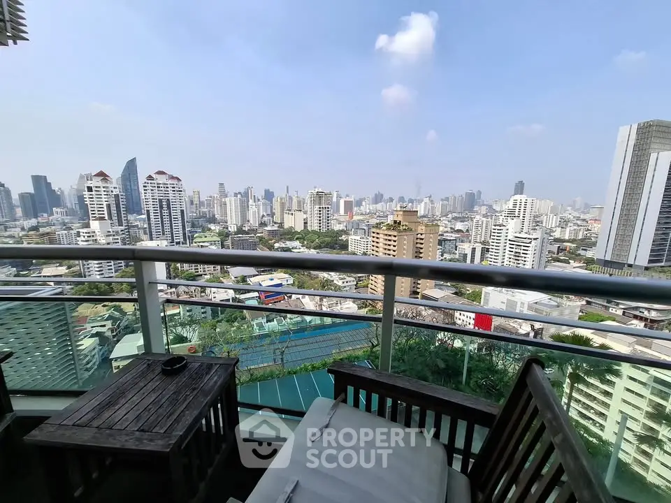 Stunning cityscape view from a high-rise balcony with modern outdoor furniture.