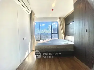 Modern bedroom with city view and large windows in high-rise apartment