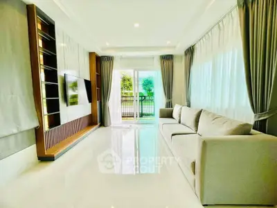 Spacious modern living room with large windows and elegant decor, offering a bright and inviting atmosphere.